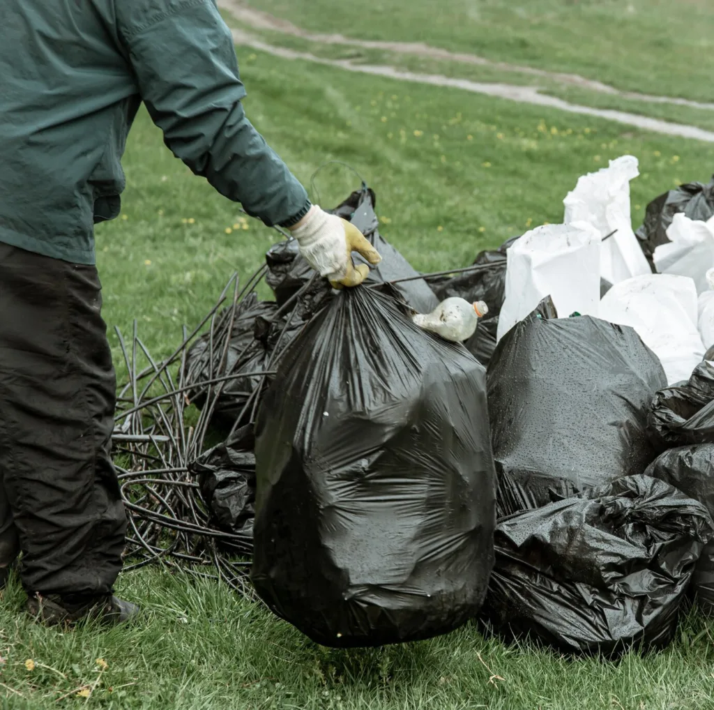 Yard Waste Removal - Putting Garden Waste in Bags to cleanout the garden - Junk removal Service by Dumpster Crews