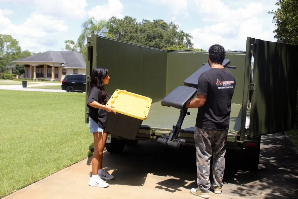 "Dumpster Crews team loading furniture and boxes into a truck during a property cleanout and junk removal service.