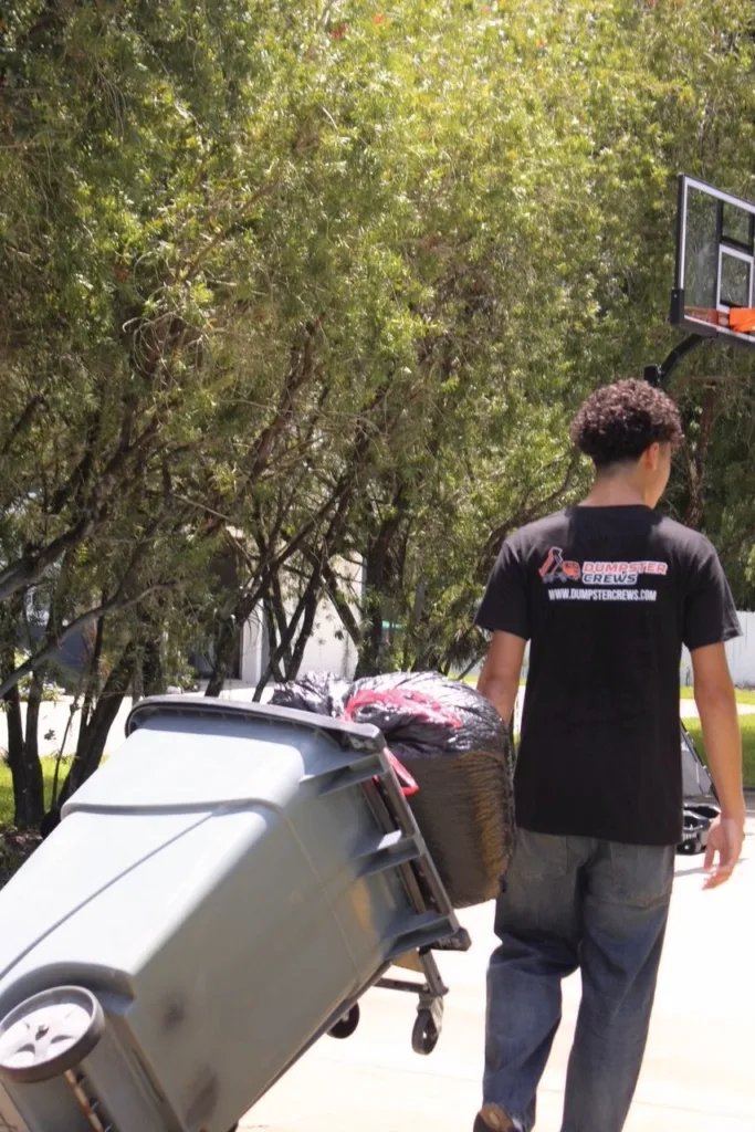 dumpster Crews member Moving Bin for Residential Junk Removal Service